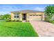 Charming single-story home features a well-manicured lawn, brick driveway, and a welcoming entrance at 2406 Kennington Cv, Deland, FL 32724