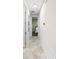 Tiled hallway showcasing the home's layout and leading to a bedroom with neutral walls and complementary flooring at 2406 Kennington Cv, Deland, FL 32724