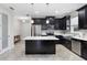 Modern kitchen with dark cabinetry, stainless steel appliances, and a central island at 2406 Kennington Cv, Deland, FL 32724