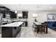 Modern kitchen with stainless steel appliances, an island with white countertop and dark cabinets at 2406 Kennington Cv, Deland, FL 32724