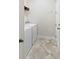 Functional laundry room with washer, dryer, storage shelf and tiled floor for easy cleaning and organization at 2406 Kennington Cv, Deland, FL 32724