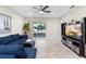 Bright living room featuring a blue sofa, ceiling fan and sliding glass doors to the outdoor patio at 2406 Kennington Cv, Deland, FL 32724