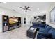 Bright living room features tile floors, a ceiling fan, and open concept kitchen in the background at 2406 Kennington Cv, Deland, FL 32724