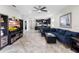 Open-concept living room with tile floors, large sofa, media center and open to kitchen in background at 2406 Kennington Cv, Deland, FL 32724