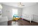 Cozy bedroom with a crib, playhouse, dark wood laminate flooring, and ceiling fan at 2448 Newmark Dr, Deltona, FL 32738
