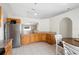 Well-lit kitchen with stainless steel refrigerator, wooden cabinets, and granite countertops at 2448 Newmark Dr, Deltona, FL 32738