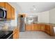 Well-lit kitchen with granite countertops, stainless steel appliances, and wooden cabinets at 2448 Newmark Dr, Deltona, FL 32738