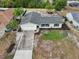An aerial view of a home with a large driveway, landscaping, and a gray roof at 2486 Shiprock Ct, Deltona, FL 32738