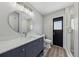 Bathroom featuring gray vanity, round mirror, a white toilet, and glass shower with wood-look floors at 2486 Shiprock Ct, Deltona, FL 32738
