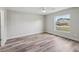 A light-filled bedroom features sleek flooring, a ceiling fan, and a bright window, offering comfort and style at 2486 Shiprock Ct, Deltona, FL 32738