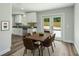 Bright dining area features a modern table set, seamlessly connected to a well-lit kitchen and backyard access at 2486 Shiprock Ct, Deltona, FL 32738