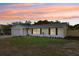 Single-story home with a well-manicured front lawn, a two-car garage, and beautiful sunset views at 2486 Shiprock Ct, Deltona, FL 32738