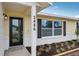 Beautiful front door with black trim, house number, and colorful landscaping at 2486 Shiprock Ct, Deltona, FL 32738