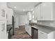 Modern kitchen featuring white cabinetry, stainless steel appliances, and granite countertops at 2486 Shiprock Ct, Deltona, FL 32738