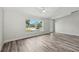 Spacious living room featuring wood-look flooring, neutral paint, and a large window at 2486 Shiprock Ct, Deltona, FL 32738