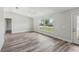 Bright living room showcasing wood-look flooring, a ceiling fan, and a large window overlooking the yard at 2486 Shiprock Ct, Deltona, FL 32738