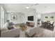 Open-concept living room with modern furnishings and seamless flow to the dining and kitchen areas at 2486 Shiprock Ct, Deltona, FL 32738