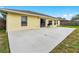 Exterior home view featuring sliding glass doors to a concrete patio and a large grassy backyard at 2526 Chester Ave, New Smyrna Beach, FL 32168