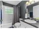 This bathroom features a shower-tub combo, tile surround, and dark gray accent wall at 2526 Chester Ave, New Smyrna Beach, FL 32168