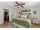 Cozy bedroom with a decorative shelf above the bed, a ceiling fan, and wood-look floors at 2526 Chester Ave, New Smyrna Beach, FL 32168