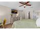 The primary bedroom has a ceiling fan, wood-look floors, a TV, and closet and bathroom access at 2526 Chester Ave, New Smyrna Beach, FL 32168