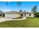 Charming single-story home featuring a well-manicured lawn and a two-car garage and bright exterior color at 2526 Chester Ave, New Smyrna Beach, FL 32168