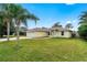 Single-story home with an attached two-car garage, well-maintained lawn, and mature palm trees at 2526 Chester Ave, New Smyrna Beach, FL 32168