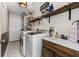 This laundry room offers a sink, wooden shelves, tile floors, washer, and dryer at 2526 Chester Ave, New Smyrna Beach, FL 32168