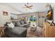 Living room featuring a comfortable gray sectional couch, natural light, and open layout to kitchen at 2526 Chester Ave, New Smyrna Beach, FL 32168