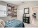 Bedroom featuring a blue quilted bedspread, built-in shelving, and an open doorway leading to an office at 260 Teddy Rushing St, Debary, FL 32713