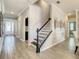 Bright hallway featuring wood-look tile floors, staircase, and view of the front door at 260 Teddy Rushing St, Debary, FL 32713