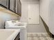 Laundry room boasts patterned flooring, upper cabinets, and modern washing machine at 260 Teddy Rushing St, Debary, FL 32713