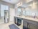 Bright main bathroom showcasing double sinks with granite countertops, walk-in shower, and a large mirror at 260 Teddy Rushing St, Debary, FL 32713