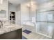 Bright main bathroom showcasing double sinks, walk-in closet, soaking tub, and luxurious tiled shower with glass door at 260 Teddy Rushing St, Debary, FL 32713