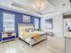 Spacious main bedroom with a tray ceiling, blue accent wall, and wood-look tile flooring at 260 Teddy Rushing St, Debary, FL 32713