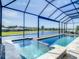 Relaxing pool and spa enclosed in a screened lanai with view of a large pond at 260 Teddy Rushing St, Debary, FL 32713