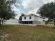 View of home's back exterior featuring solar panels and large yard at 2709 Sedgefield Ave, Deltona, FL 32725