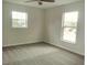 Bright bedroom featuring two windows with views, neutral walls, and comfortable carpet flooring at 2709 Sedgefield Ave, Deltona, FL 32725