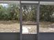 Screened-in lanai offering peaceful views of the backyard's lush greenery and natural landscape at 2709 Sedgefield Ave, Deltona, FL 32725