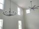 Bright living room with soaring ceilings, modern chandelier, and ample natural light at 2709 Sedgefield Ave, Deltona, FL 32725