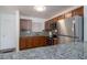 Modern kitchen featuring stainless appliances, granite counters, and wood cabinets at 2711 N Halifax Ave # 496, Daytona Beach, FL 32118