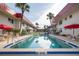 Community pool is surrounded by buildings, palm trees, and lounge chairs at 2711 N Halifax Ave # 496, Daytona Beach, FL 32118