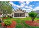 Inviting backyard with a screened-in patio, beautiful landscaping, and mature trees providing ample shade at 276 Gala Cir, Daytona Beach, FL 32124