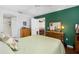 Spacious bedroom featuring green accent wall, hardwood floors, and view of the ensuite bathroom at 276 Gala Cir, Daytona Beach, FL 32124