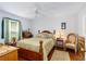 Comfortable bedroom with a classic wooden bed frame, hardwood floors, and natural light from the window at 276 Gala Cir, Daytona Beach, FL 32124