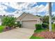 Well-maintained home with a two-car garage, adorned with mature landscaping and charming front yard details at 276 Gala Cir, Daytona Beach, FL 32124