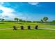 Scenic view of the golf course with Adirondack chairs under a blue sky with fluffy white clouds at 276 Gala Cir, Daytona Beach, FL 32124