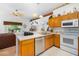 Bright kitchen features white appliances and wooden cabinets, seamlessly flowing into the living area at 276 Gala Cir, Daytona Beach, FL 32124