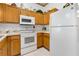 Functional kitchen featuring white appliances, tile flooring, and ample cabinet space at 276 Gala Cir, Daytona Beach, FL 32124