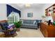 Bright living room with a cozy rocking chair, and a large window with curtains at 276 Gala Cir, Daytona Beach, FL 32124